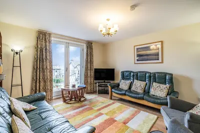 a living room with a couch and a tv at Hillberry in Grange Over Sands
