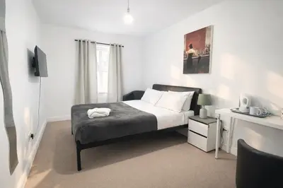 a bedroom with a bed and a desk with a television at BEST DEAL - Kings Hotel in Blackburn
