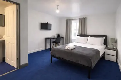 a hotel room with a bed and a mirror at BEST DEAL - Kings Hotel in Blackburn