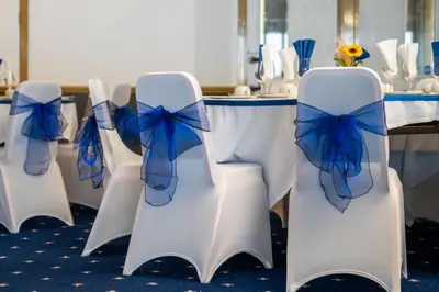 a row of white chairs with blue bows at a table at The Strathmore Hotel in Morecambe