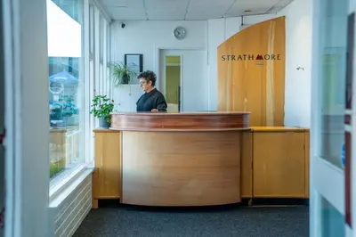 a man standing behind a counter in a office at The Strathmore Hotel in Morecambe