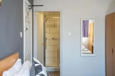 a bathroom with a shower and a mirror on the wall at The Strathmore Hotel in Morecambe