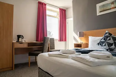 a hotel room with a bed with towels on it at The Strathmore Hotel in Morecambe