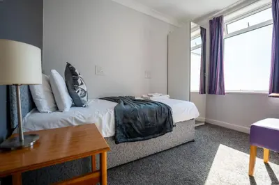a bedroom with a bed and a desk and a window at The Strathmore Hotel in Morecambe