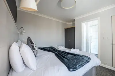 a bedroom with a bed with white sheets and pillows at The Strathmore Hotel in Morecambe