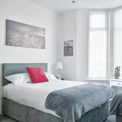 a bedroom with a large bed with a red pillow at Priory Suites in Liverpool