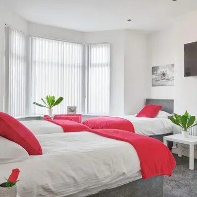 a bedroom with two beds with red blankets on them at Priory Suites in Liverpool