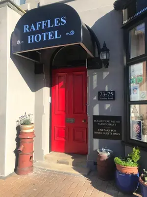 a red door of a hotel with a sign above it at Raffles Hotel in Blackpool