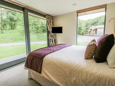 a bedroom with a large bed and a large window at Neddy Cut in Ulverston