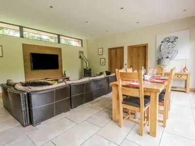 a living room with a table and a tv at Neddy Cut in Ulverston