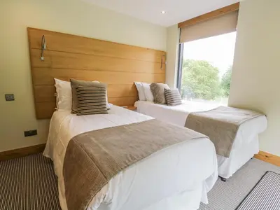 two beds in a room with a window at Neddy Cut in Ulverston
