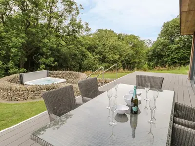 a white table with a bottle of wine on a deck at Neddy Cut in Ulverston