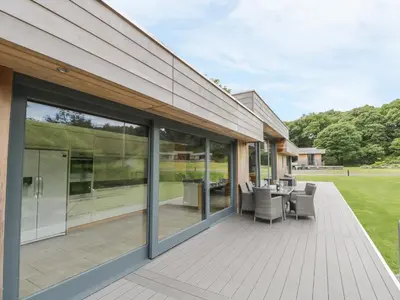 a patio with sliding glass doors and a table and chairs at Neddy Cut in Ulverston