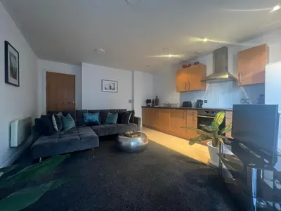 a living room with a couch and a kitchen at Stunning City Centre Apartment, Benson Street, Liverpool 1 in Liverpool