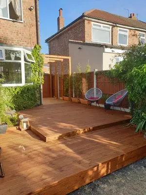 a wooden deck in the backyard of a house at Luxury 5* Home with Secret Garden and Free Parking in Liverpool