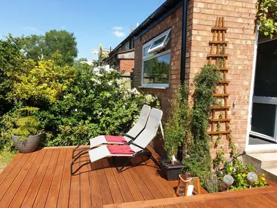 a white chair sitting on a wooden deck at Luxury 5* Home with Secret Garden and Free Parking in Liverpool