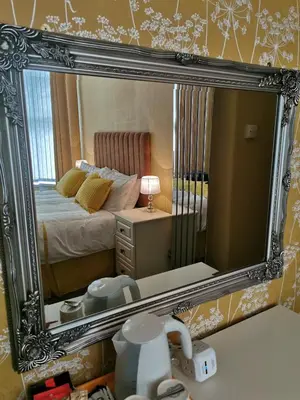 a mirror reflecting a bedroom with a bed and a table at THE QUORN HOTEL in Blackpool