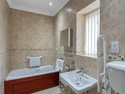 a bathroom with a sink and a tub and a toilet at Granada Apartments Burbage in Blackpool