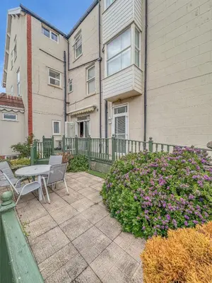 a patio with a table and chairs in front of a building at Granada Apartments Burbage in Blackpool