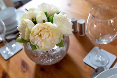 a vase filled with white flowers on a table at The World Famous Henderson House in Liverpool