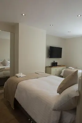 a bedroom with a large bed and a television at The Kings Cross Hotel in Blackpool