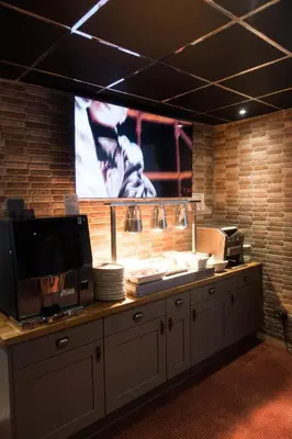 a kitchen with a large tv on a brick wall at The Kings Cross Hotel in Blackpool