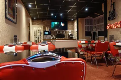 a restaurant with red chairs and a dining room at The Kings Cross Hotel in Blackpool