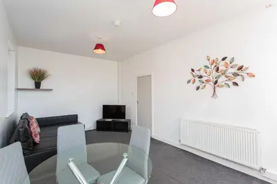 a living room with a glass table and chairs at Cherry Property - Mulberry Suite in Blackpool
