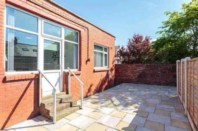 a brick house with a glass door and stairs at Cherry Property - Mulberry Suite in Blackpool
