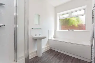 a white bathroom with a sink and a bath tub and a window at Cherry Property - Mulberry Suite in Blackpool