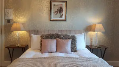 a bedroom with a bed with two lamps and a picture on the wall at The Ambassador Townhouse in Southport