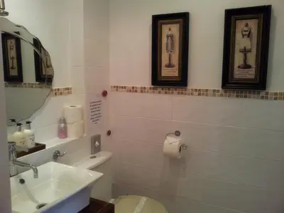 a bathroom with a sink and a toilet and a mirror at The Ambassador Townhouse in Southport
