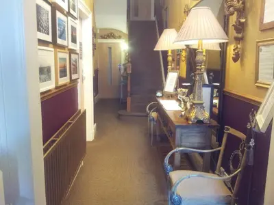 a hallway with a desk with a lamp and a staircase at The Ambassador Townhouse in Southport
