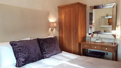 a bedroom with a bed and a desk and a mirror at The Ambassador Townhouse in Southport