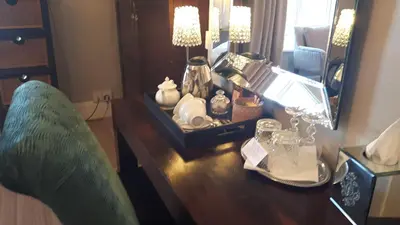 a vanity with a mirror and a chair in a room at The Ambassador Townhouse in Southport