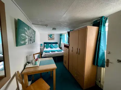 a small room with a bed and a desk and a bedroom at Beeches Hotel in Blackpool