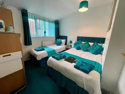 a hotel room with two beds with blue pillows at Beeches Hotel in Blackpool