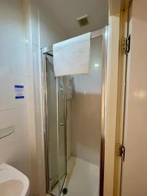 a shower with a glass door in a bathroom at Beeches Hotel in Blackpool