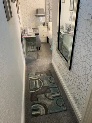 a hallway with a mirror and a tile floor at Sorrento House in Blackpool