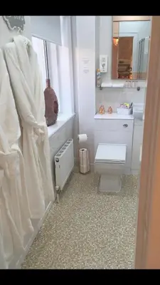 a white bathroom with a toilet and a sink at Sorrento House in Blackpool