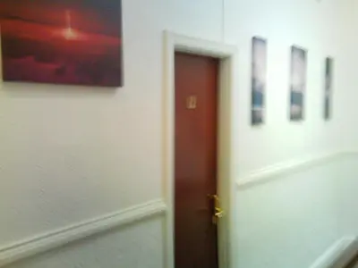 a door in a room with three pictures on the wall at Arlingtons in Blackpool