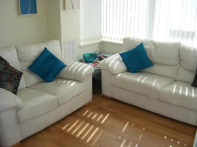 a living room with two white couches and blue pillows at Arlingtons in Blackpool
