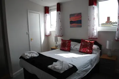 a bedroom with a large bed with red pillows at Brincliffe Hotel in Blackpool