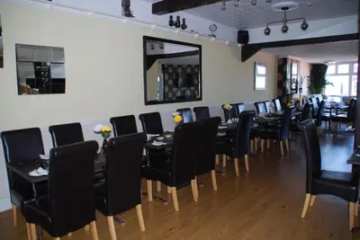 a dining room with black chairs and tables and a mirror at Brincliffe Hotel in Blackpool