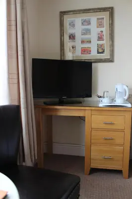 a desk with a flat screen tv on top of it at The Ashley in Morecambe