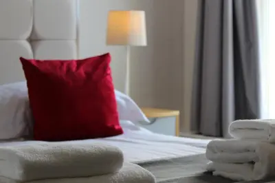 a room with a bed with a red pillow and a red at The Ashley in Morecambe