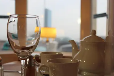 a table with a wine glass and cups on it at The Ashley in Morecambe