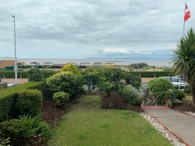 a garden with trees and bushes and a flag at Savoy in Fleetwood
