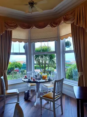 a dining room with a table and chairs in front of a window at Savoy in Fleetwood