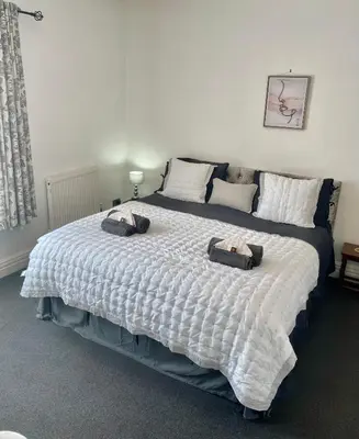 a bedroom with a large bed with two pillows on it at Entire holiday home in Blackpool with free parking and a private patio garden in Blackpool